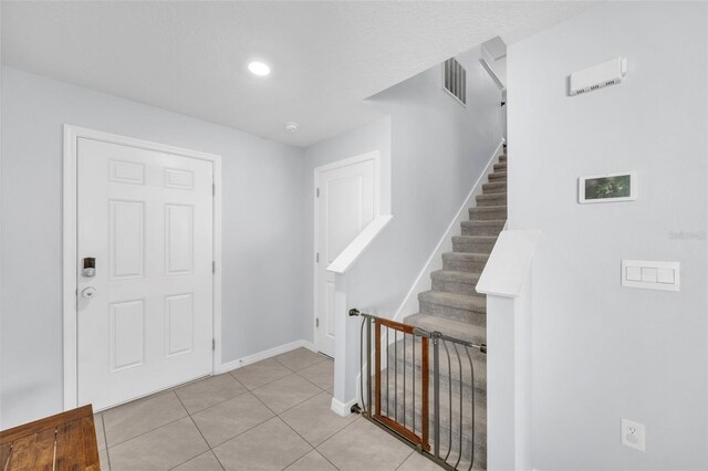entrance foyer featuring baseboards, visible vents, recessed lighting, stairs, and light tile patterned floors