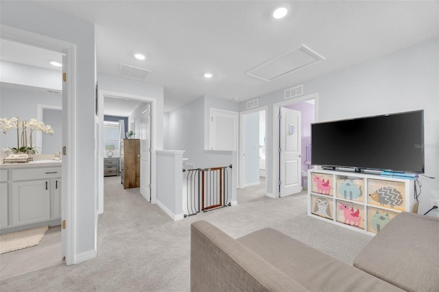 living area with light carpet, visible vents, and recessed lighting