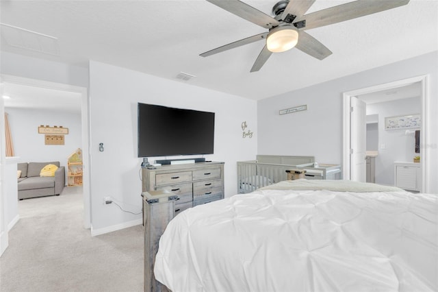 bedroom featuring visible vents, baseboards, light colored carpet, ceiling fan, and connected bathroom
