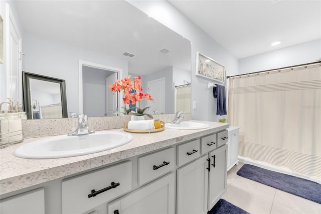 bathroom with double vanity, visible vents, tile patterned floors, and a sink