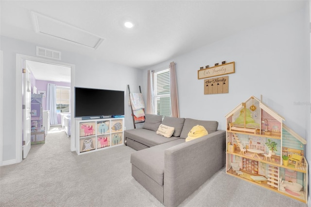 carpeted living area featuring attic access and visible vents