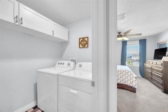 clothes washing area featuring washing machine and dryer, baseboards, cabinet space, light colored carpet, and ceiling fan