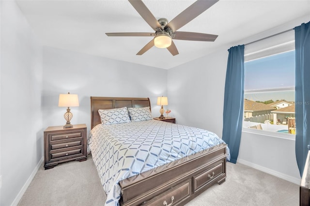 bedroom with ceiling fan, light carpet, and baseboards