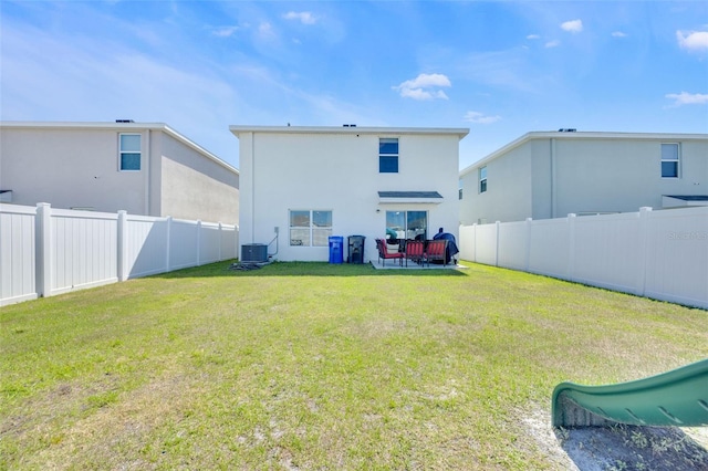 rear view of property featuring a fenced backyard, central AC unit, a yard, and stucco siding