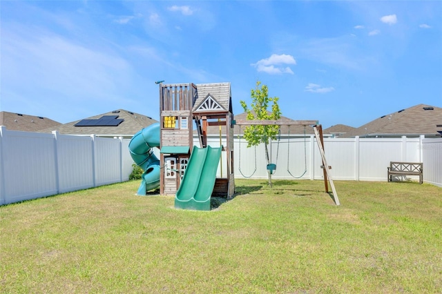 view of playground with a lawn and a fenced backyard