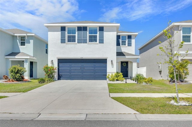 view of front facade with an attached garage, a front yard, stucco siding, and driveway