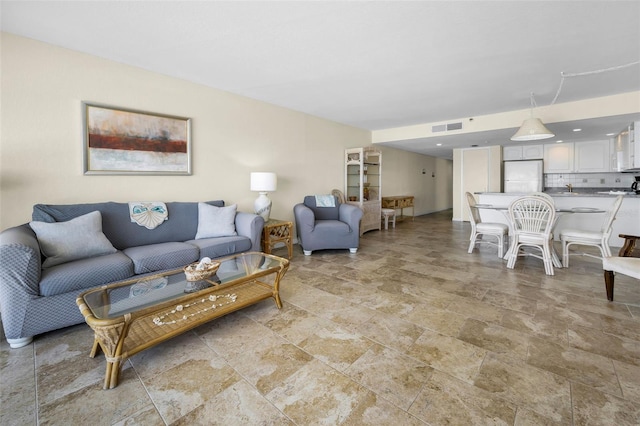 living area featuring visible vents and stone finish flooring