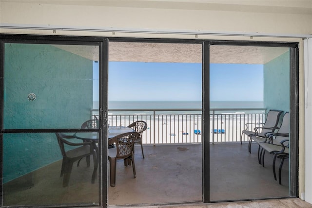 sunroom with a beach view and a water view