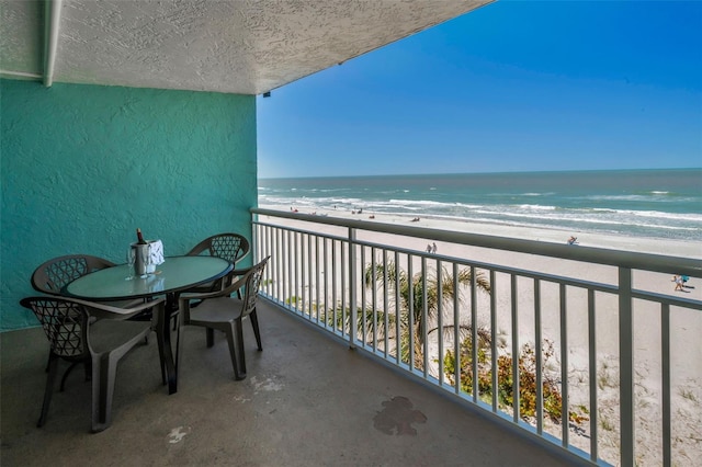 balcony featuring a beach view and a water view