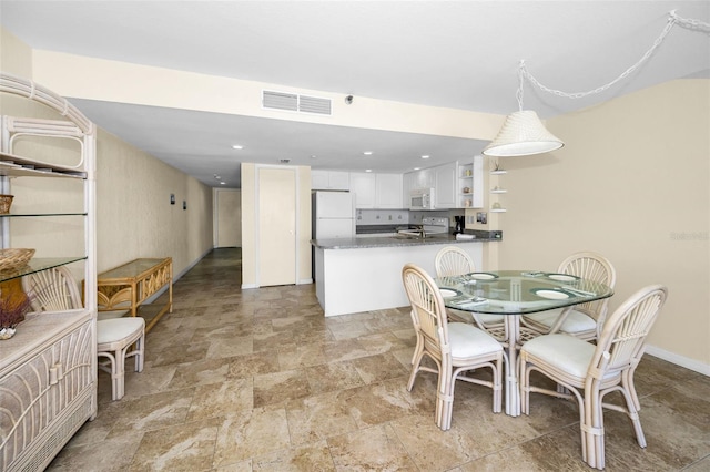 dining room with baseboards, visible vents, stone finish flooring, and recessed lighting