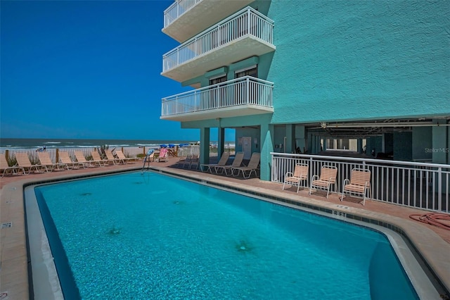 community pool with a patio and a water view