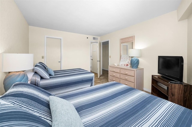 bedroom featuring visible vents, baseboards, and light colored carpet