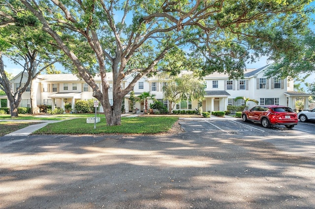 13777 Forest Lake Dr, Largo, FL 33771 - townhome / multi-family property with uncovered parking, a front lawn, and a residential view