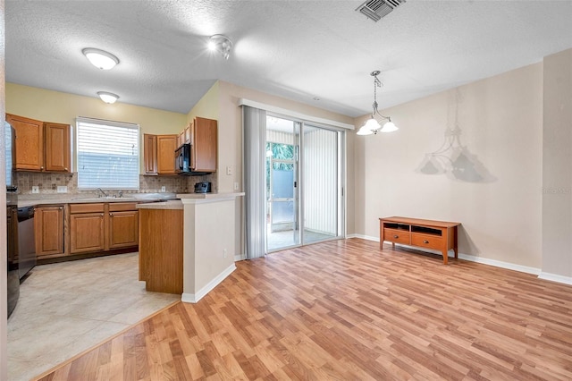 13777 Forest Lake Dr, Largo, FL 33771 - kitchen featuring light countertops, visible vents, black microwave, light wood-type flooring, and tasteful backsplash