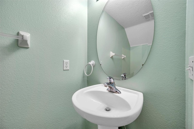 13777 Forest Lake Dr, Largo, FL 33771 - bathroom featuring a textured wall, a sink, and visible vents