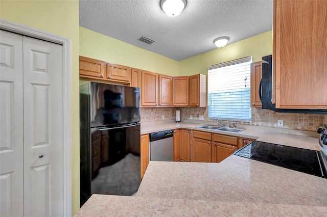 13777 Forest Lake Dr, Largo, FL 33771 - kitchen featuring stainless steel dishwasher, a sink, a textured ceiling, freestanding refrigerator, and range with electric stovetop