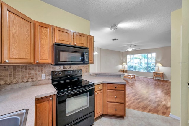 13777 Forest Lake Dr, Largo, FL 33771 - kitchen featuring light countertops, a sink, backsplash, and black appliances