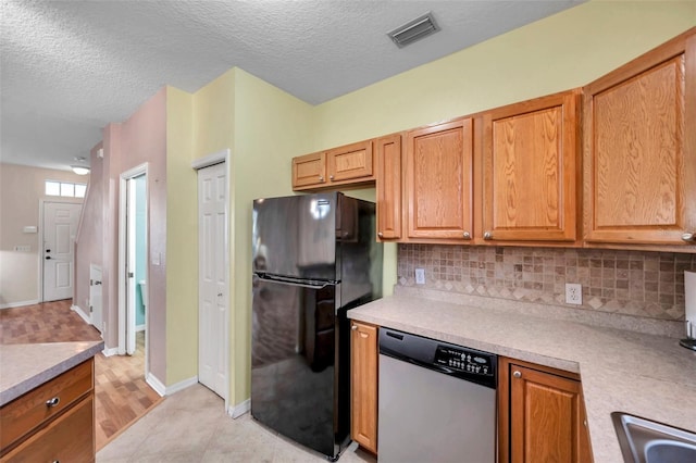 13777 Forest Lake Dr, Largo, FL 33771 - kitchen featuring dishwasher, tasteful backsplash, visible vents, and freestanding refrigerator