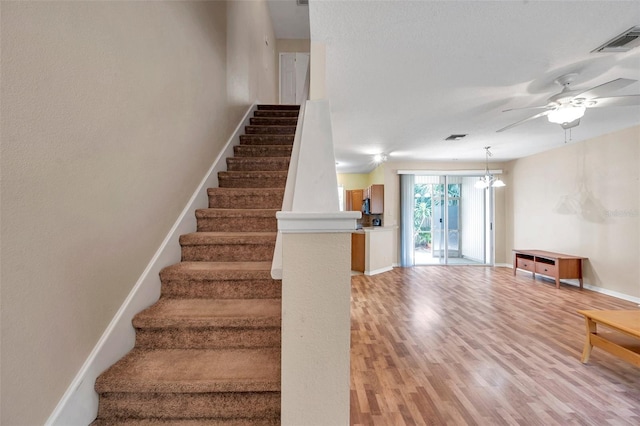 13777 Forest Lake Dr, Largo, FL 33771 - staircase featuring baseboards, wood finished floors, visible vents, and ceiling fan