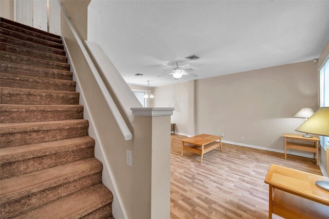 13777 Forest Lake Dr, Largo, FL 33771 - stairway featuring wood finished floors, visible vents, a ceiling fan, and baseboards