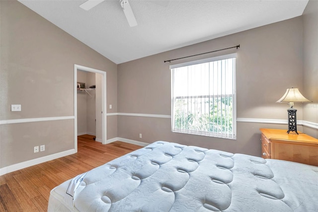 13777 Forest Lake Dr, Largo, FL 33771 - bedroom with baseboards, lofted ceiling, a ceiling fan, wood finished floors, and a walk in closet