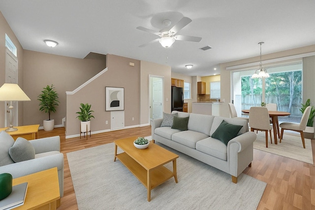 13777 Forest Lake Dr, Largo, FL 33771 - living area featuring baseboards, ceiling fan with notable chandelier, visible vents, and light wood-style flooring