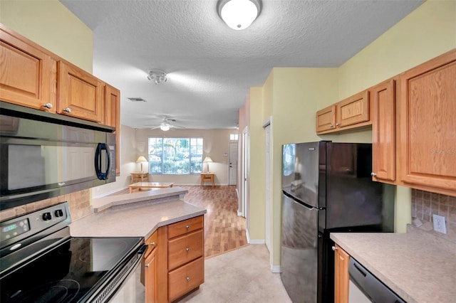 13777 Forest Lake Dr, Largo, FL 33771 - kitchen featuring a textured ceiling, tasteful backsplash, visible vents, light countertops, and black appliances