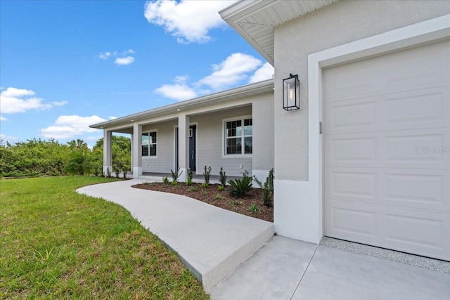 10493 Grail Ave, Englewood, FL 34224 - entrance to property with a porch, a yard, a garage, and stucco siding