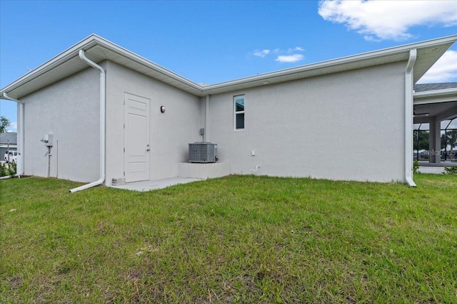 10493 Grail Ave, Englewood, FL 34224 - back of house with a yard, central air condition unit, and stucco siding