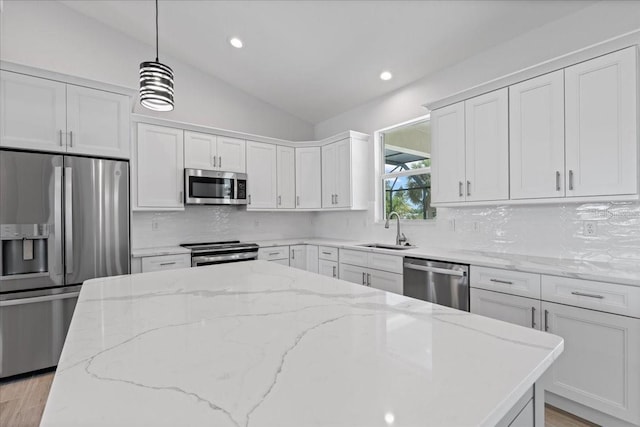 10493 Grail Ave, Englewood, FL 34224 - kitchen featuring a sink, appliances with stainless steel finishes, decorative backsplash, a kitchen island, and lofted ceiling