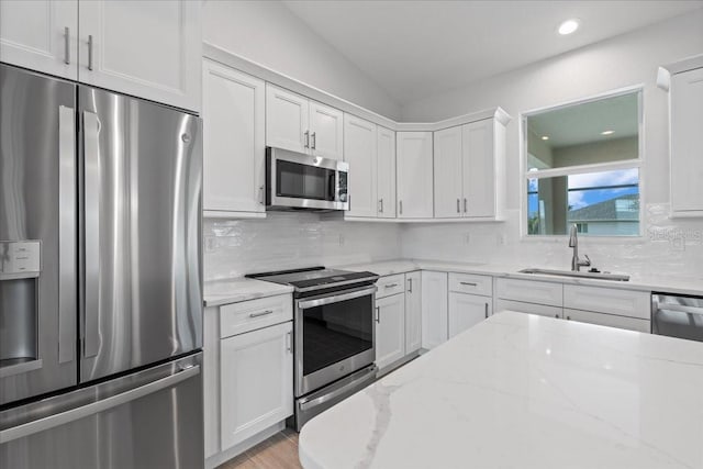 10493 Grail Ave, Englewood, FL 34224 - kitchen with a sink, decorative backsplash, white cabinetry, and stainless steel appliances