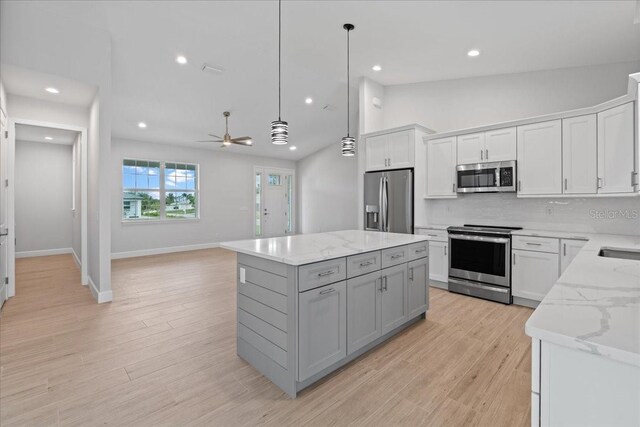 10493 Grail Ave, Englewood, FL 34224 - kitchen with tasteful backsplash, a ceiling fan, a kitchen island, stainless steel appliances, and decorative light fixtures
