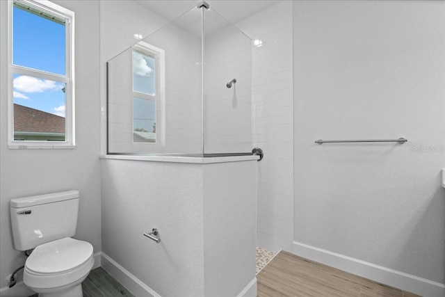10493 Grail Ave, Englewood, FL 34224 - full bath with baseboards, walk in shower, toilet, and wood finished floors
