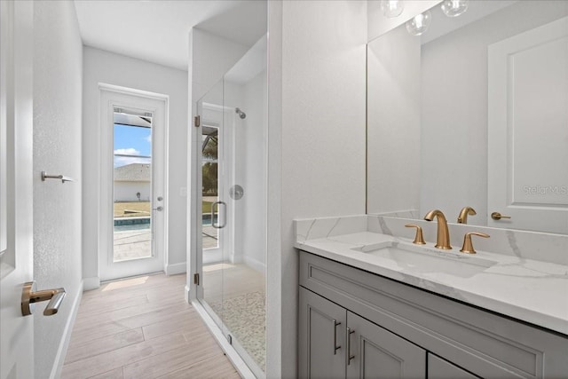 10493 Grail Ave, Englewood, FL 34224 - full bath featuring baseboards, vanity, wood finished floors, and walk in shower