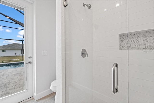 10493 Grail Ave, Englewood, FL 34224 - bathroom with toilet, baseboards, a stall shower, and wood finished floors