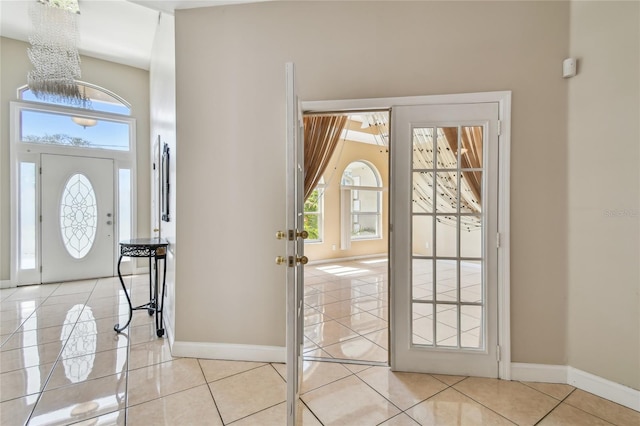 284 Peninsula Ave, Tarpon Springs, FL 34689 - entrance foyer with tile patterned flooring, baseboards, a chandelier, and a towering ceiling