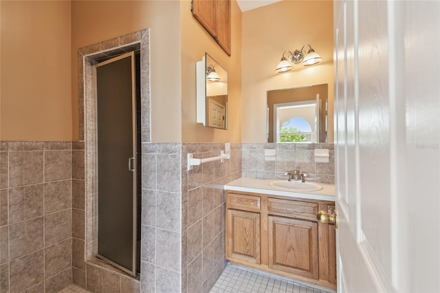 284 Peninsula Ave, Tarpon Springs, FL 34689 - full bath with tile walls, a stall shower, a wainscoted wall, vanity, and tile patterned flooring