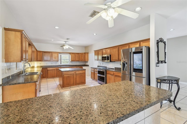 284 Peninsula Ave, Tarpon Springs, FL 34689 - kitchen with stainless steel appliances, ceiling fan, a sink, a kitchen island, and light tile patterned flooring