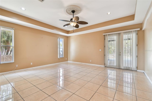 284 Peninsula Ave, Tarpon Springs, FL 34689 - spare room with a tray ceiling, ceiling fan, light tile patterned flooring, baseboards, and recessed lighting