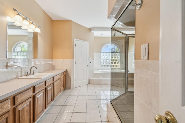 284 Peninsula Ave, Tarpon Springs, FL 34689 - full bathroom featuring tile patterned floors, vanity, a bath, wainscoting, and tile walls