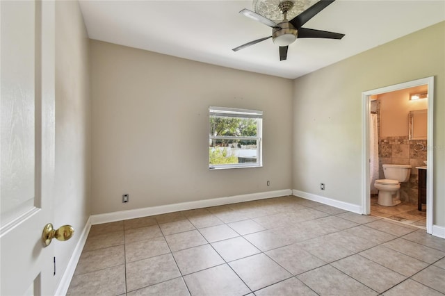 284 Peninsula Ave, Tarpon Springs, FL 34689 - unfurnished bedroom featuring light tile patterned flooring, connected bathroom, baseboards, and a ceiling fan