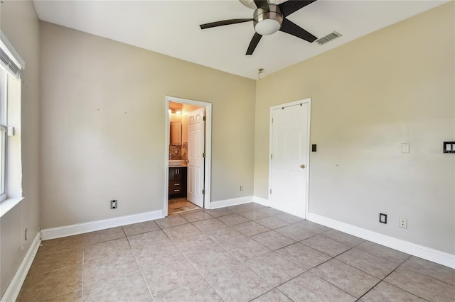 284 Peninsula Ave, Tarpon Springs, FL 34689 - unfurnished bedroom with light tile patterned flooring, baseboards, and ensuite bath