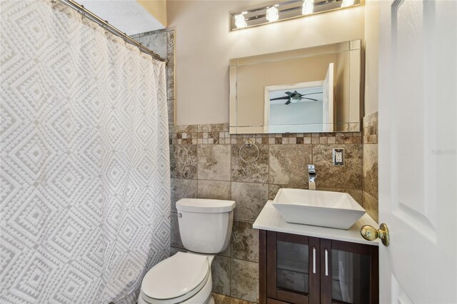284 Peninsula Ave, Tarpon Springs, FL 34689 - full bath with tile walls, toilet, vanity, ceiling fan, and wainscoting