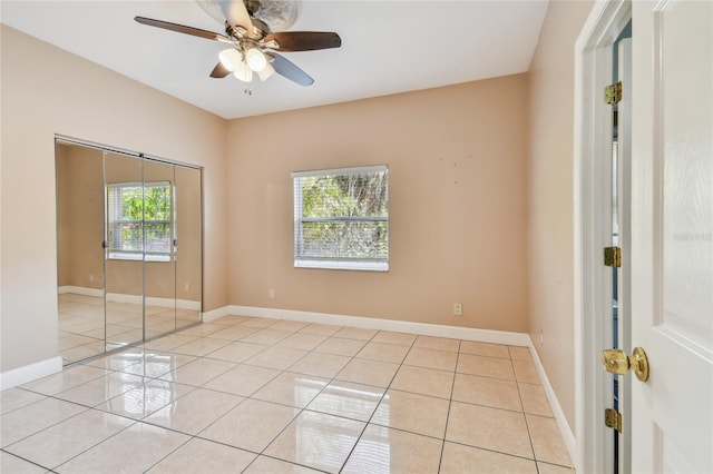 284 Peninsula Ave, Tarpon Springs, FL 34689 - unfurnished bedroom with light tile patterned floors, baseboards, ceiling fan, and a closet