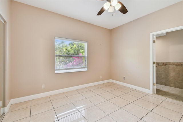 284 Peninsula Ave, Tarpon Springs, FL 34689 - unfurnished bedroom with light tile patterned flooring, baseboards, ensuite bathroom, and a ceiling fan