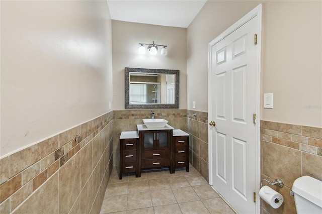 284 Peninsula Ave, Tarpon Springs, FL 34689 - bathroom featuring tile walls, tile patterned flooring, wainscoting, toilet, and vanity
