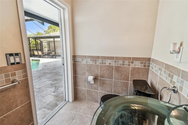 284 Peninsula Ave, Tarpon Springs, FL 34689 - bathroom featuring tile walls and a wainscoted wall