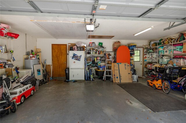 35109 Excalibur, Webster, FL 33597 - garage featuring water heater, freestanding refrigerator, and a garage door opener