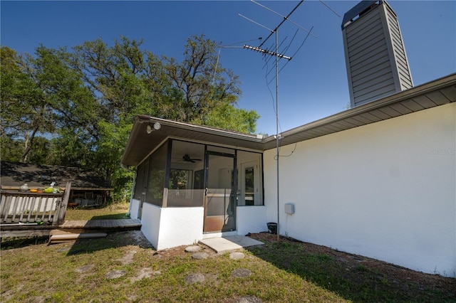 35109 Excalibur, Webster, FL 33597 - exterior space featuring a wooden deck, a sunroom, stucco siding, a lawn, and a chimney