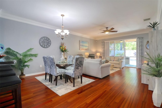 1023 Orca Ct, Holiday, FL 34691 - dining room with ceiling fan with notable chandelier, wood finished floors, visible vents, and crown molding